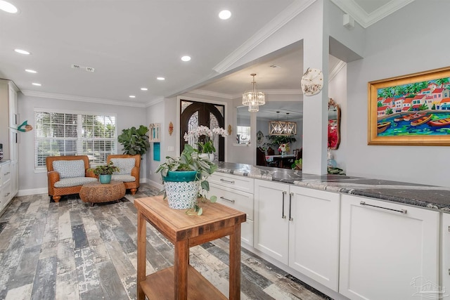 living room featuring ornamental molding, an inviting chandelier, and light hardwood / wood-style floors