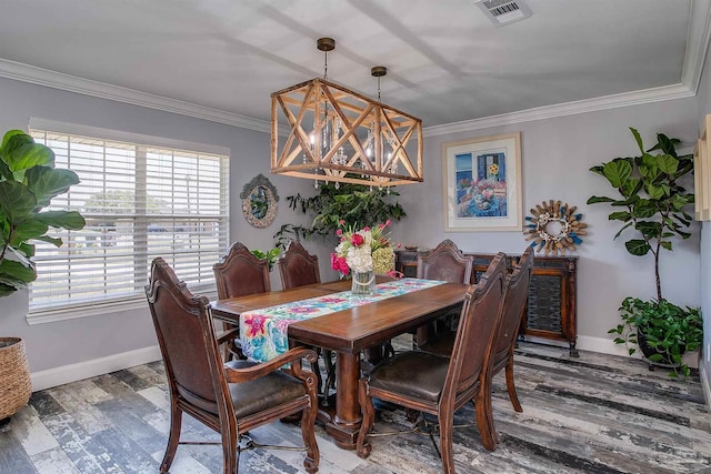 dining space with ornamental molding, hardwood / wood-style flooring, and a chandelier