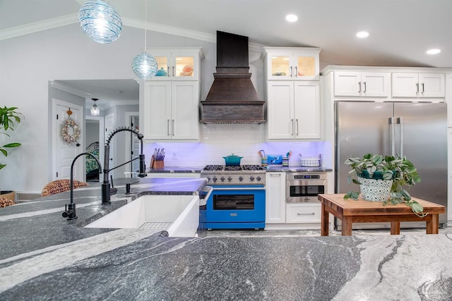 kitchen featuring high end appliances, sink, hanging light fixtures, backsplash, and custom range hood