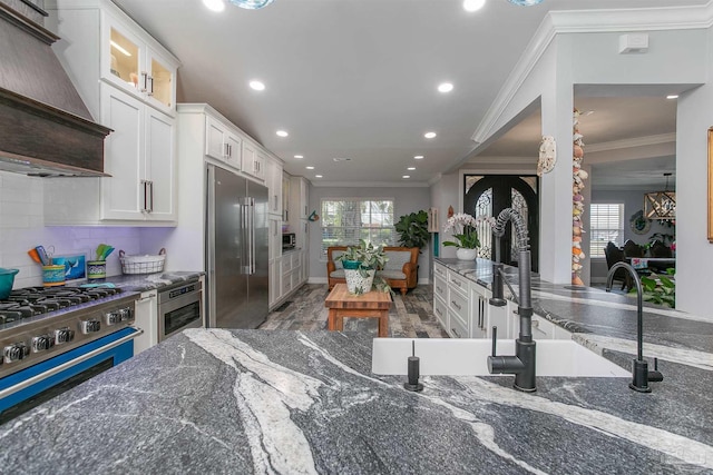 kitchen with white cabinets, stainless steel built in fridge, crown molding, custom exhaust hood, and wine cooler