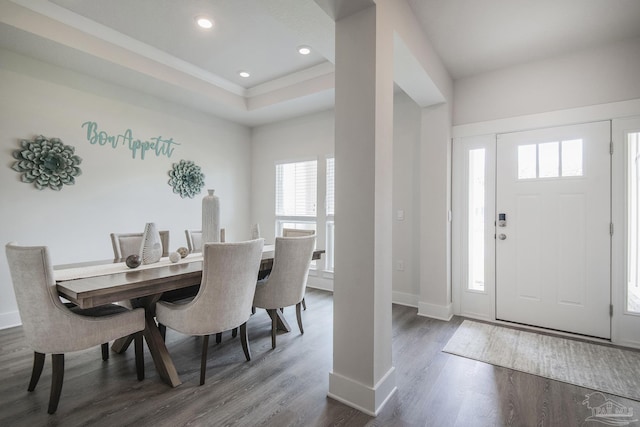 dining area featuring dark wood-type flooring, recessed lighting, a raised ceiling, and baseboards