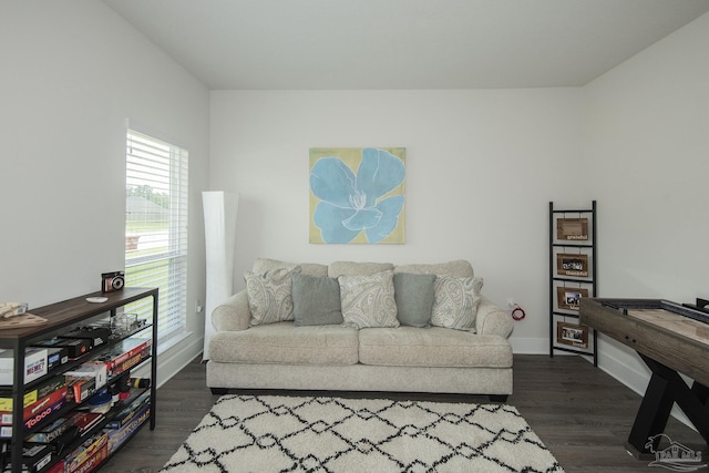 living area with dark wood-type flooring and baseboards