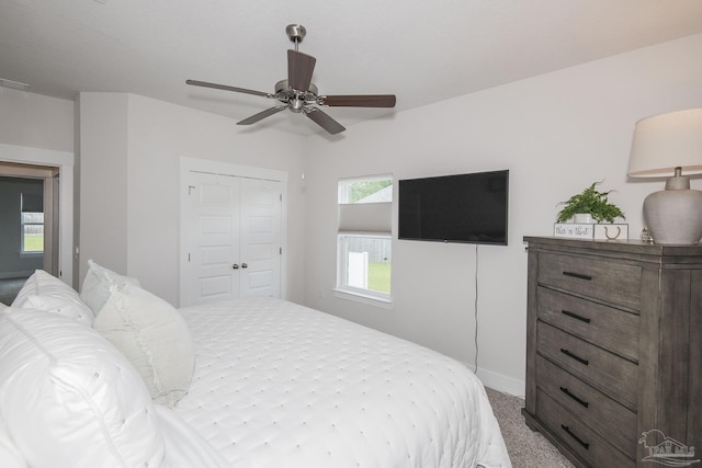 bedroom with ceiling fan, a closet, carpet flooring, and baseboards