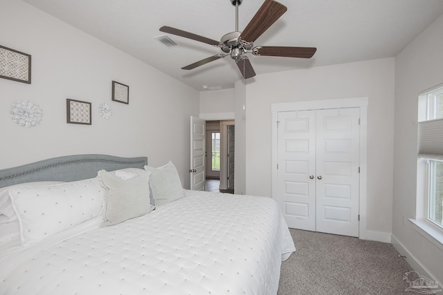 bedroom featuring baseboards, visible vents, light colored carpet, ceiling fan, and a closet