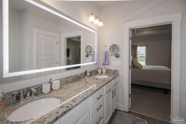 ensuite bathroom featuring double vanity, ensuite bath, and a sink