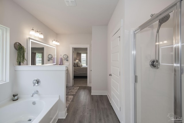 ensuite bathroom with visible vents, ensuite bathroom, a shower with shower door, wood finished floors, and a bath