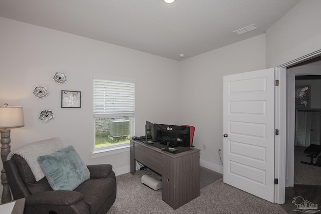 carpeted office featuring visible vents and baseboards