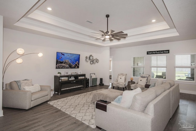 living room with dark wood finished floors, a fireplace, a raised ceiling, visible vents, and ceiling fan