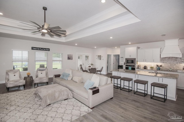 living room featuring visible vents, a raised ceiling, ceiling fan, wood finished floors, and recessed lighting