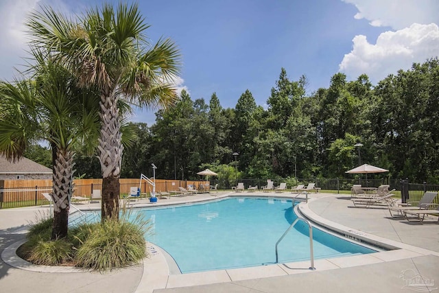 pool featuring fence and a patio