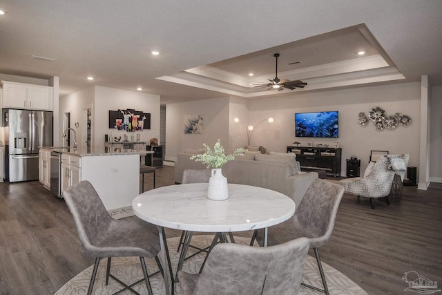 dining space featuring ceiling fan, a raised ceiling, dark wood-style flooring, and recessed lighting