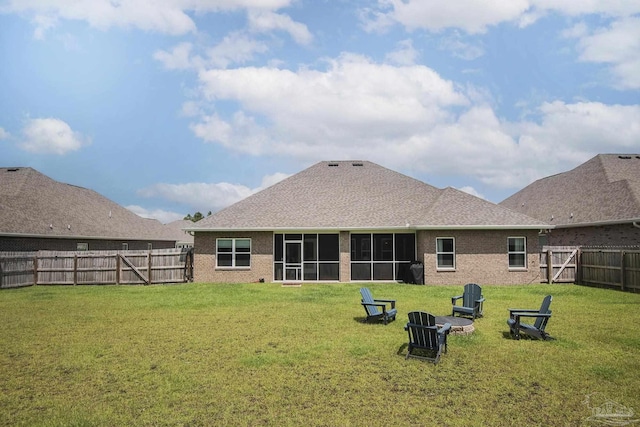 back of house featuring a yard, brick siding, a fenced backyard, and a gate