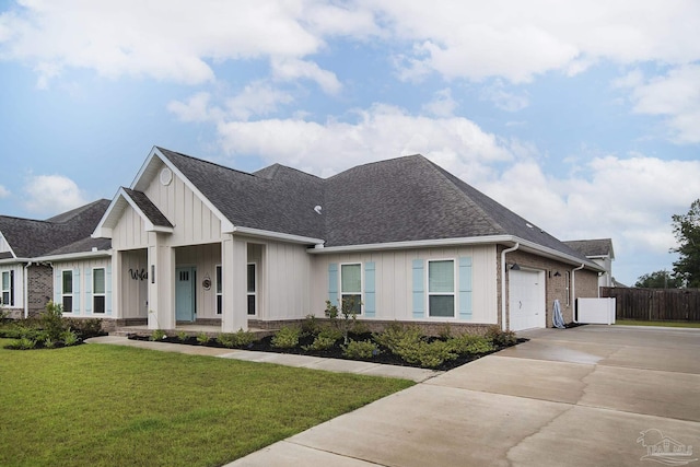 view of front facade featuring board and batten siding, a front lawn, concrete driveway, and brick siding