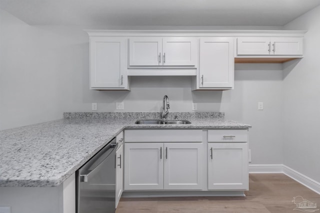 kitchen featuring baseboards, white cabinets, light stone countertops, stainless steel dishwasher, and a sink