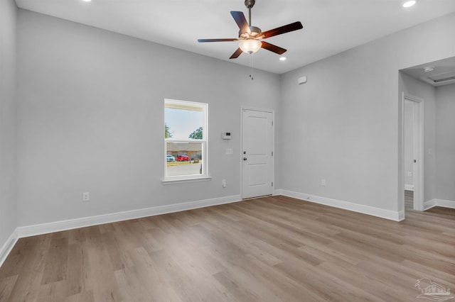 spare room with baseboards, a ceiling fan, and light wood-style floors