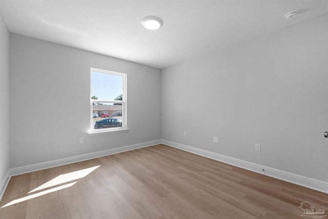 spare room with light wood-type flooring and baseboards