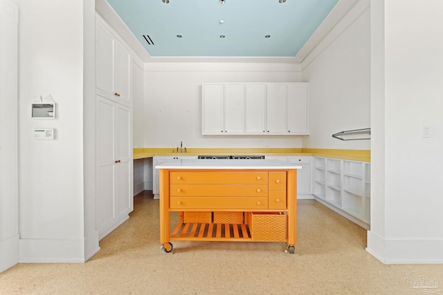 kitchen featuring white cabinetry, sink, and ornamental molding