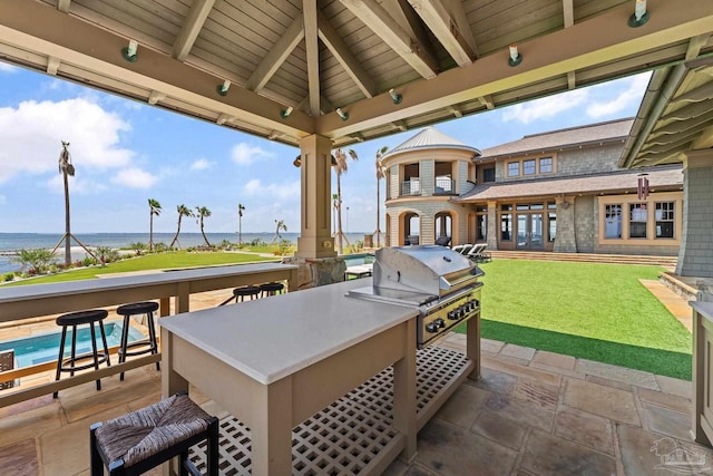 view of patio featuring a gazebo, a water view, grilling area, and a bar