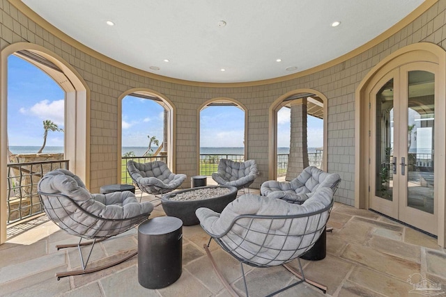 view of patio / terrace with french doors, a water view, and a fire pit