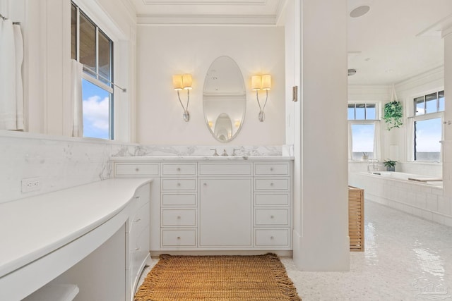 bathroom with tiled tub, crown molding, and vanity