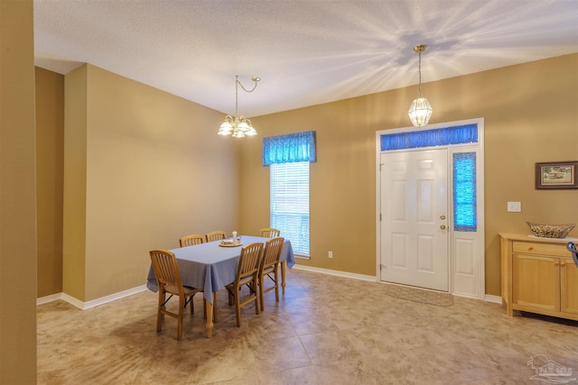 dining room with an inviting chandelier and a textured ceiling