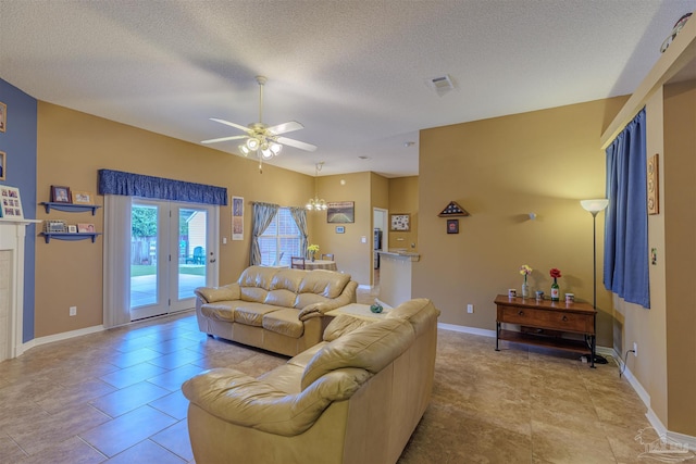 tiled living room featuring ceiling fan with notable chandelier and a textured ceiling