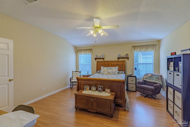 bedroom with light hardwood / wood-style flooring, ceiling fan, and a textured ceiling