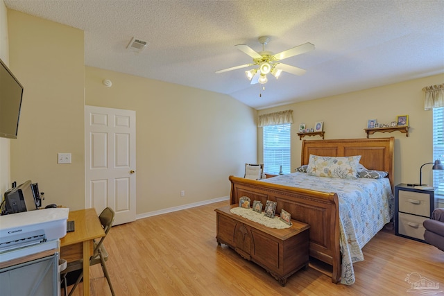 bedroom with multiple windows, light hardwood / wood-style floors, vaulted ceiling, and ceiling fan