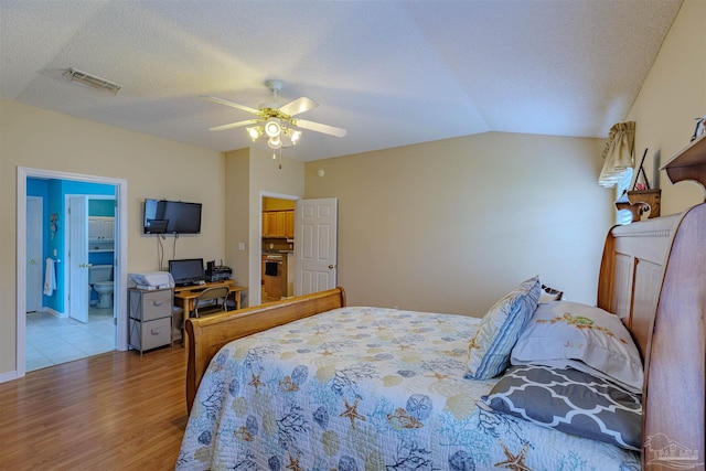 bedroom featuring ceiling fan, a textured ceiling, light hardwood / wood-style flooring, and lofted ceiling