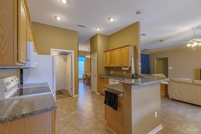 kitchen with white appliances, kitchen peninsula, a textured ceiling, stone counters, and ceiling fan