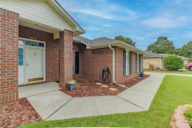 doorway to property with a lawn