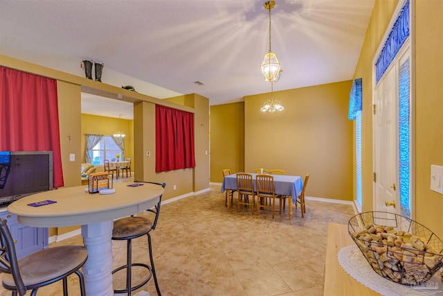 dining area with a textured ceiling and a chandelier