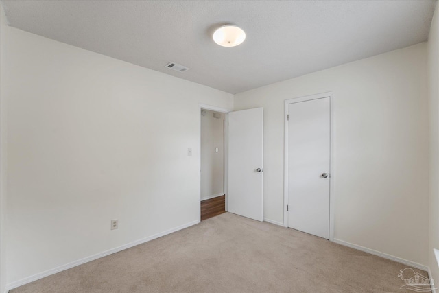 unfurnished bedroom with light carpet and a closet