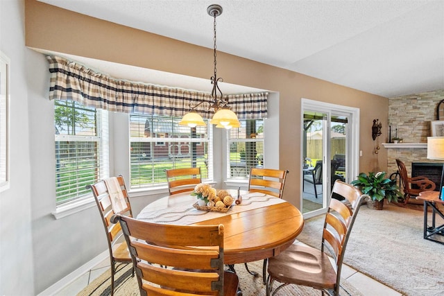 917 Broken Arrow Ln, Pensacola, FL 32533 - dining area with a chandelier, baseboards, tile patterned floors, a textured ceiling, and a stone fireplace