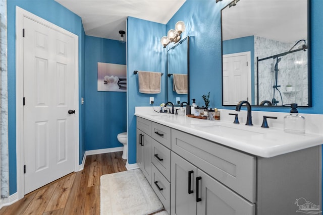 917 Broken Arrow Ln, Pensacola, FL 32533 - full bathroom with a stall shower, wood finished floors, toilet, double vanity, and baseboards