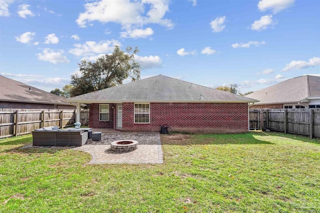 rear view of property with a yard, an outdoor living space with a fire pit, and a patio area