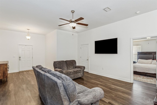 living room featuring ceiling fan and dark wood-type flooring