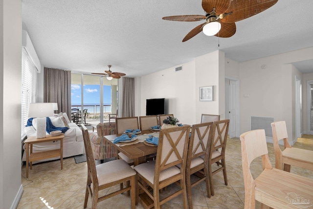 dining area featuring ceiling fan, light tile patterned flooring, and a textured ceiling