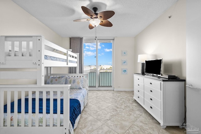 bedroom with access to exterior, a textured ceiling, ceiling fan, and light tile patterned flooring