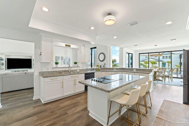 kitchen with pendant lighting, sink, a kitchen breakfast bar, dark hardwood / wood-style floors, and white cabinets