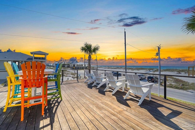 deck at dusk featuring a water view