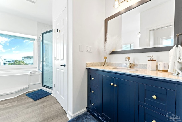 bathroom featuring vanity, wood-type flooring, and plus walk in shower