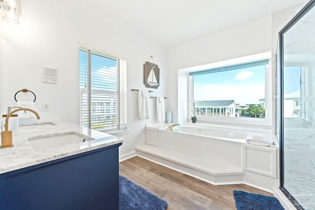 bathroom with independent shower and bath, wood-type flooring, and vanity