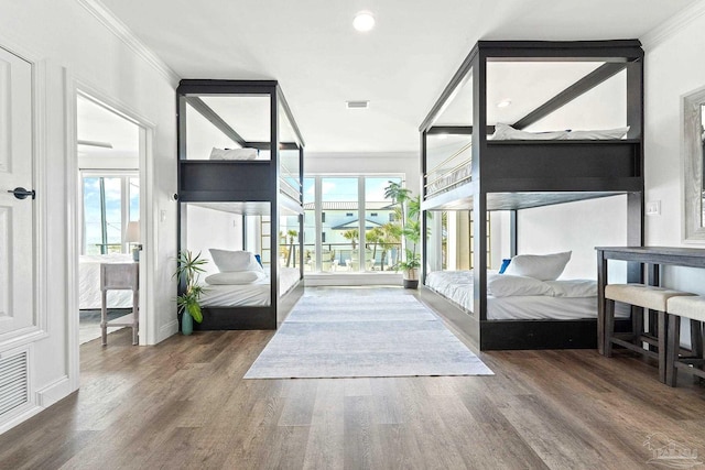 bedroom featuring multiple windows, crown molding, and dark wood-type flooring