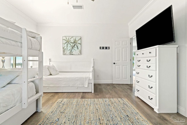 bedroom with ornamental molding and dark hardwood / wood-style floors