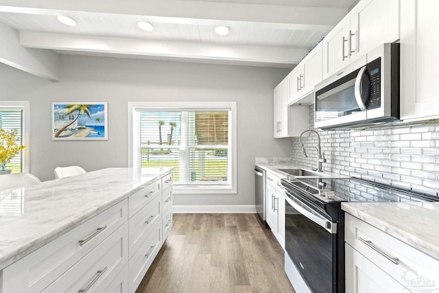 kitchen featuring beamed ceiling, white cabinetry, sink, decorative backsplash, and stainless steel appliances