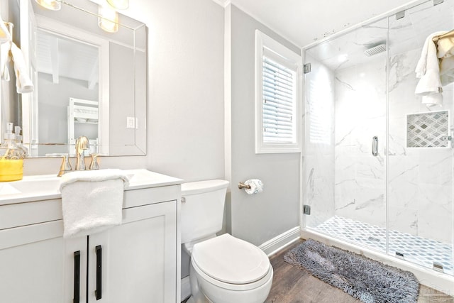 bathroom with hardwood / wood-style flooring, vanity, a shower with door, and toilet