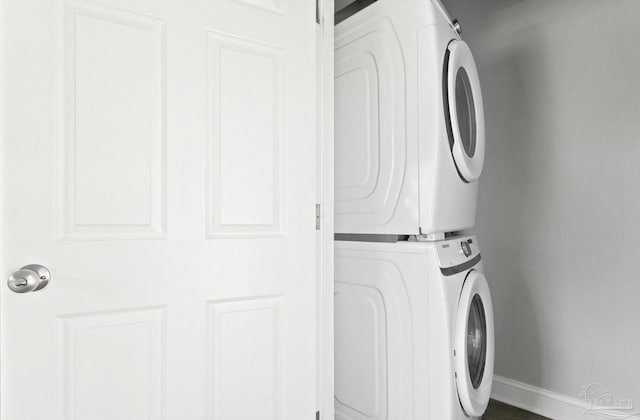 clothes washing area featuring stacked washing maching and dryer