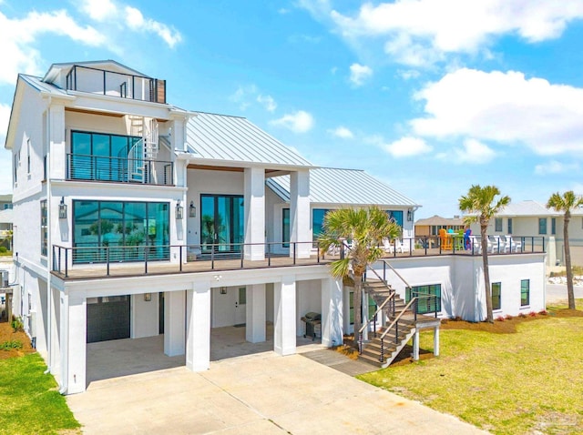 rear view of house with a garage, a yard, a carport, and a balcony