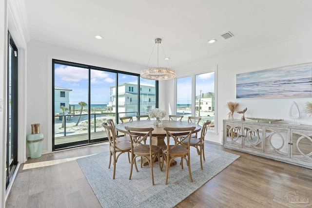 dining space featuring ornamental molding, plenty of natural light, and wood-type flooring